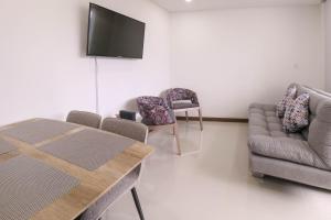 sala de estar con sofá, sillas y TV en Apartamento Hermoso y Exclusivo en el Norte, Apto 1307 T-2, en Armenia