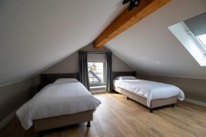 a attic bedroom with two beds and a window at UplandParcs Bergblick in Winterberg