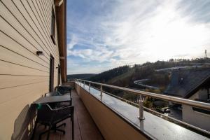 a balcony with a view of a river and trees at UplandParcs Bergblick in Winterberg