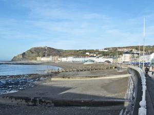 vistas a una playa con edificios y al océano en Llys y Barnwr - Judge's Court, en Aberystwyth