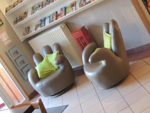 duas cadeiras sentadas numa sala de estar em Hôtel de La Vallée em Ornans