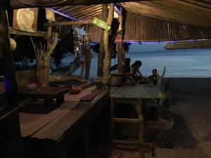 two people sitting in a hut on the beach at Dawn of Happiness in Ao Nam Mao