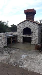 a stone oven with a bench in front of it at Apartments Limuni in Saplunara