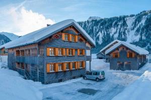 a house with a car parked in the snow at Ferienbauernhof Nigsch in Schoppernau