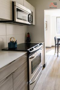 a kitchen with a stove and a microwave at ENVITAE 2BR Vibrant High-Rise Penthouse in Chicago