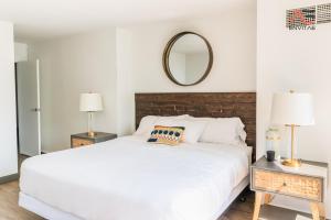 a bedroom with a white bed and a mirror at ENVITAE 2BR Vibrant High-Rise Penthouse in Chicago