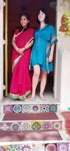 due donne che si trovano sui gradini di una casa di NAMASTEY MUMBAI BACKPACKERS a Mumbai