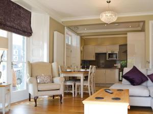 a living room with a couch and a table and a kitchen at Llys yr Wylan in Aberystwyth