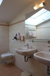 a bathroom with a sink and a toilet and a mirror at Villa Waldeck in Eppingen