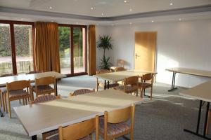 uma sala de conferências com mesas, cadeiras e janelas em Villa Waldeck em Eppingen