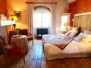 a bedroom with a bed and a table and a window at Un Patio en Luberon in Ansouis
