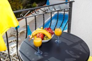 una ciotola di frutta e due bicchieri di succo d'arancia di Palmer Residence Krk a Dobrinj