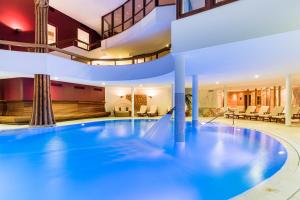 a large swimming pool in a building with a house at Granbaita Dolomites in Selva di Val Gardena