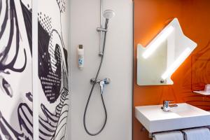 a bathroom with a sink and a shower at Ibis budget Lorient Caudan in Caudan +48 photos