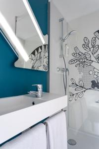 a bathroom with a sink and a shower at Ibis budget Lorient Caudan in Caudan +40 photos