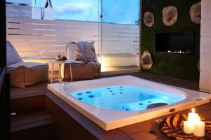 a jacuzzi tub in a room with a fireplace at Musae Relais & SPA in Polignano a Mare