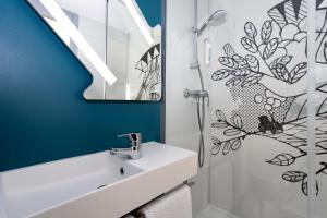 y baño con lavabo y espejo. en ibis budget Lorient Caudan, en Caudan