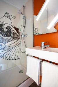 y baño con ducha y lavamanos. en ibis budget Lorient Caudan, en Caudan