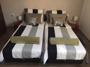 dos camas sentadas una al lado de la otra en un dormitorio en Alex Lodge, en Zrenjanin