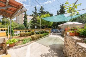 einen Garten mit Pool und Sonnenschirm in der Unterkunft Petite in Split