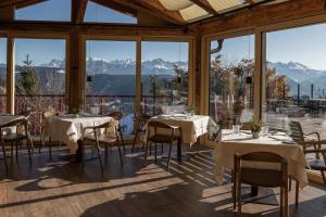 ein Restaurant mit Tischen und Stühlen und großen Fenstern in der Unterkunft Tschögglbergerhof in Jenesien
