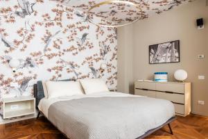 een slaapkamer met een bed en bloemenbehang bij Palazzo Visconti - by MyHomeInComo in Como