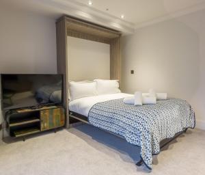 Riverside Studio Apartments Close To City Centre في يورك: غرفة نوم بسرير ومرآة كبيرة