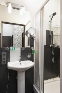 W łazience znajduje się umywalka i prysznic. w obiekcie Nevsky Forum Hotel w Petersburgu