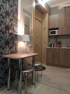 a kitchen with a table and chairs in a room at Апартаменты на ул.Шопена in Lviv