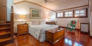 a bedroom with a bed and a desk and a chair at Pousada do Mondego in Ouro Preto