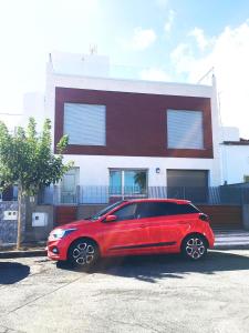 a red car parked in front of a building at La Cornisa Villa by WaveProperties in Las Palmas de Gran Canaria