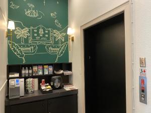 a green wall with drawings on it next to a door at The EO Inn - Downtown Orlando in Orlando