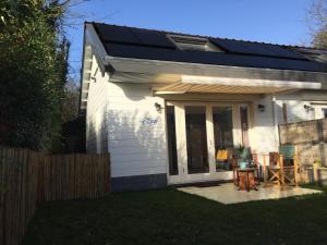 a small white house with a solar roof at Studio bij Zee in Ouddorp