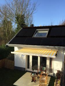 a house with a solar roof and a patio at Studio bij Zee in Ouddorp