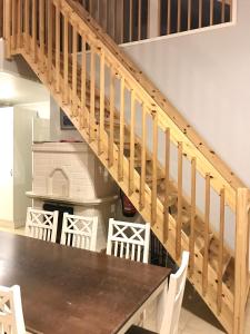 a dining room with a table and a wooden staircase at Villa Sidori in Jämsä