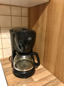 a black coffee maker sitting on a wooden shelf at Villa Sidori in Jämsä