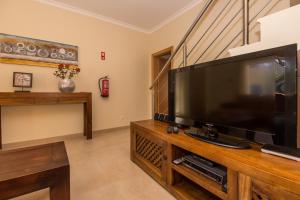 a living room with a large flat screen tv at Villa Amoreira by ALGARVEMANTA in Manta Rota