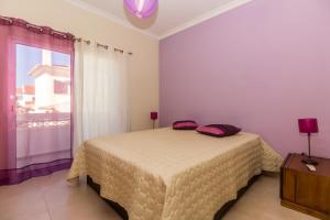 un dormitorio con una cama y una ventana en Villa Amoreira by ALGARVEMANTA, en Manta Rota