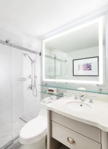 a white bathroom with a sink and a shower at Fairmont Le Chateau Montebello in Montebello