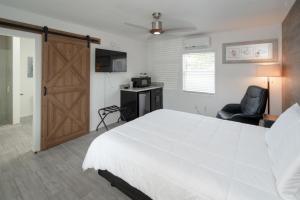 um quarto com uma grande cama branca e uma porta de correr em Sun Outdoors Key Largo em Key Largo