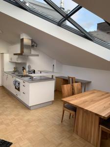 a kitchen with a wooden table and a dining room at Basic Apartments downtown in Innsbruck
