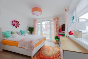 a bedroom with a large bed and a kitchen at La Maison M in Westerland