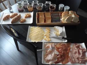 a table topped with different types of cheese and meats at Residence Sole in Trieste