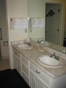 5th Street Inn في ماريبوسا: حمام به مغسلتين ومرآة كبيرة