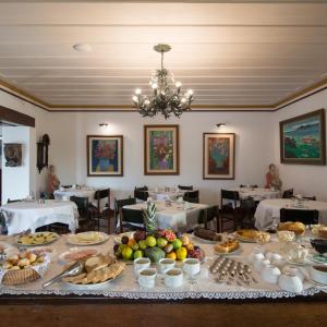 uma sala de jantar com uma mesa cheia de comida em Pousada do Mondego em Ouro Preto