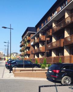un estacionamiento con autos estacionados frente a un edificio en Apartman Dragisic Kalman J15,D8 en Zlatibor