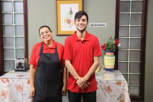 a man and a woman standing in a kitchen at Pousada Anexo in Niterói