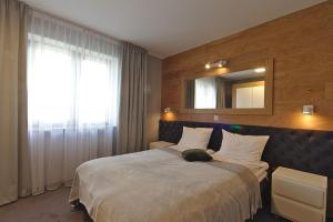 sypialnia z dużym łóżkiem i lustrem w obiekcie Apartamenty Forma Tatrica w Zakopanem