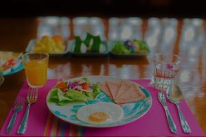 a plate of food with a egg and salad on a table at Boutique Family Room Phitsanulok in Phitsanulok