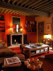 sala de estar con paredes de color naranja y chimenea en Hotel Les Templiers en Aigues-Mortes